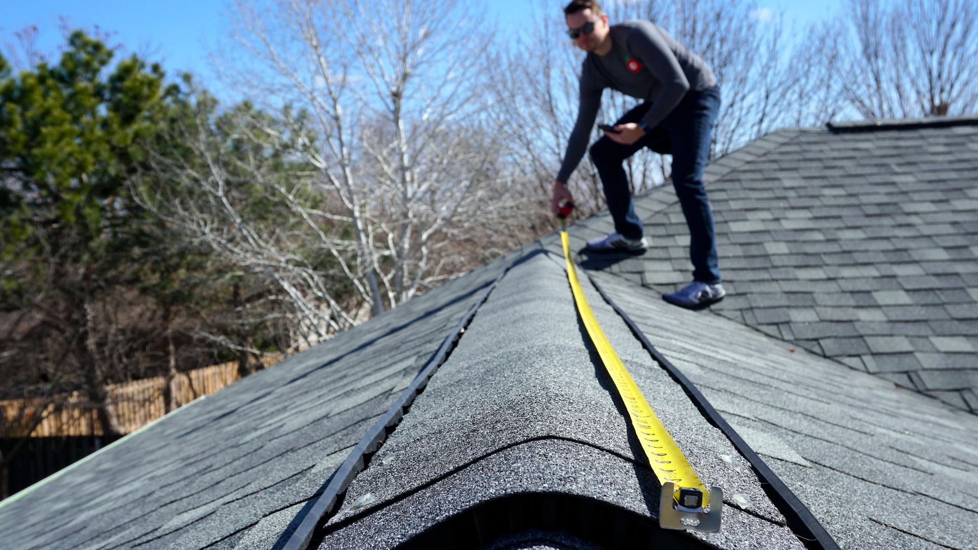 man measuring roof