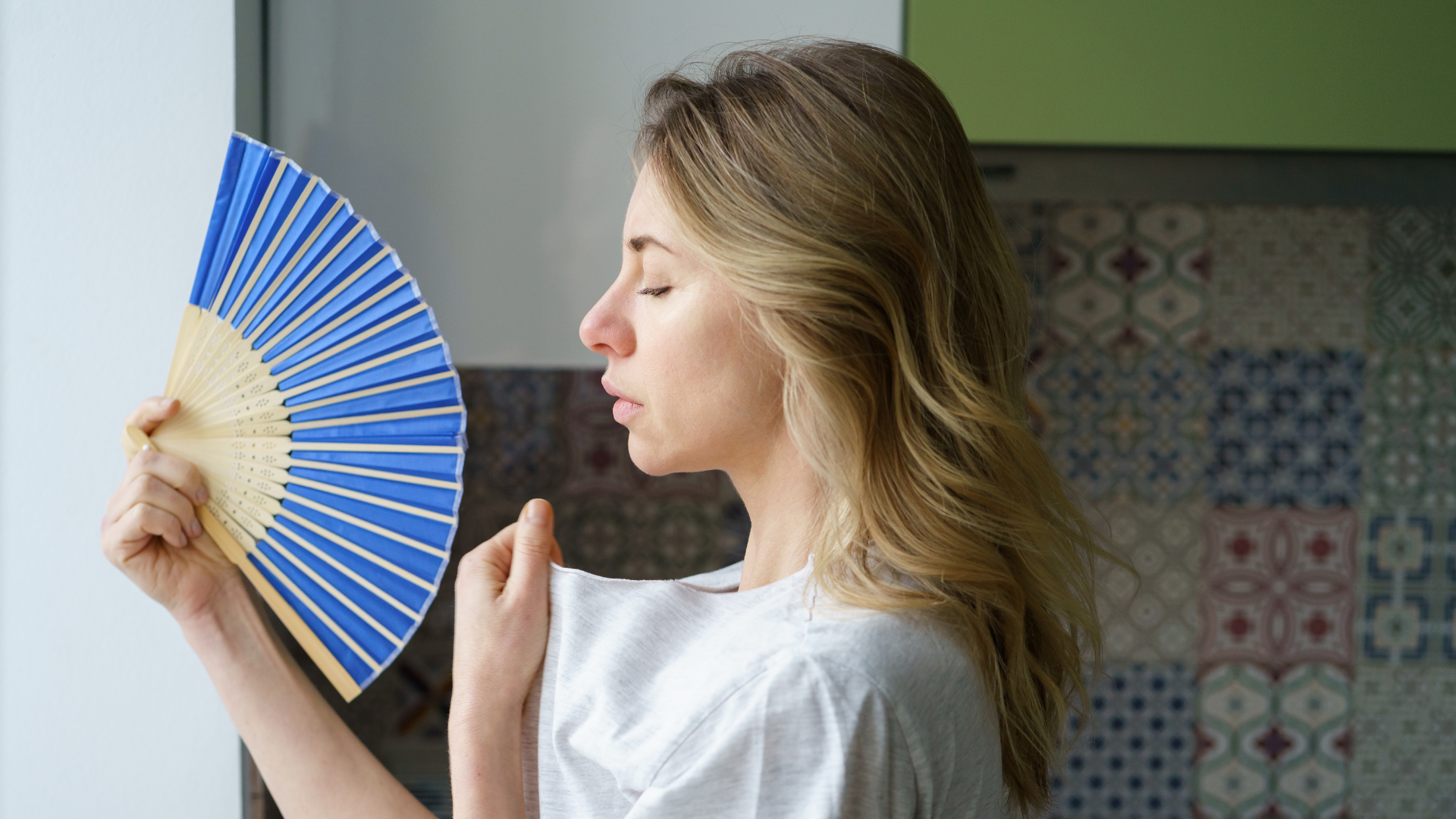 woman suffering from heat using fan